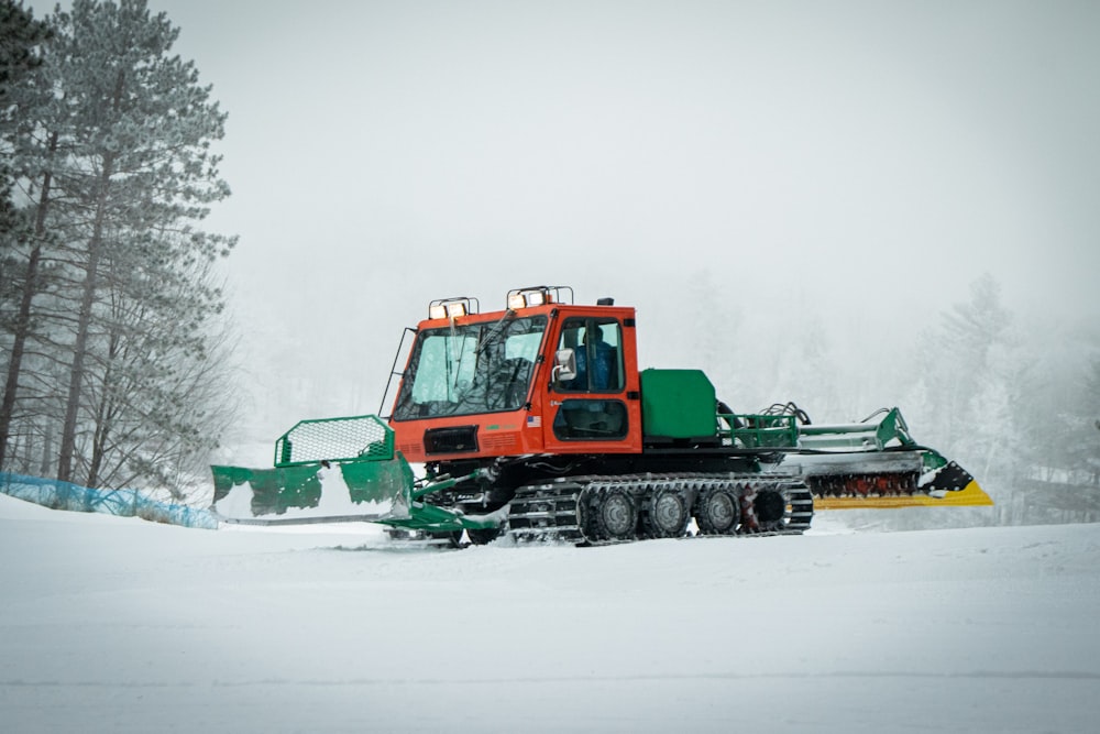 green and orange heavy equipment on snow covered ground