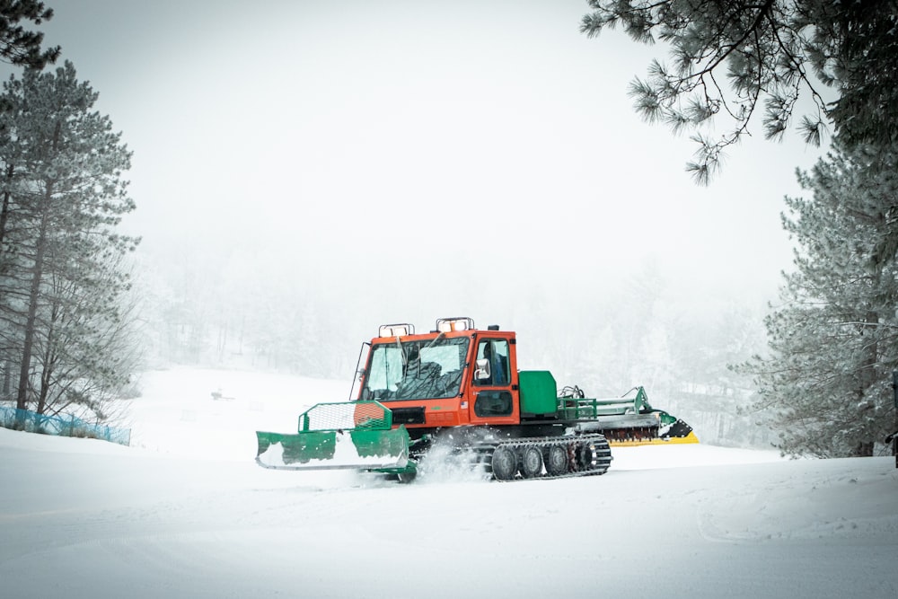 red and green heavy equipment on snow covered ground during daytime