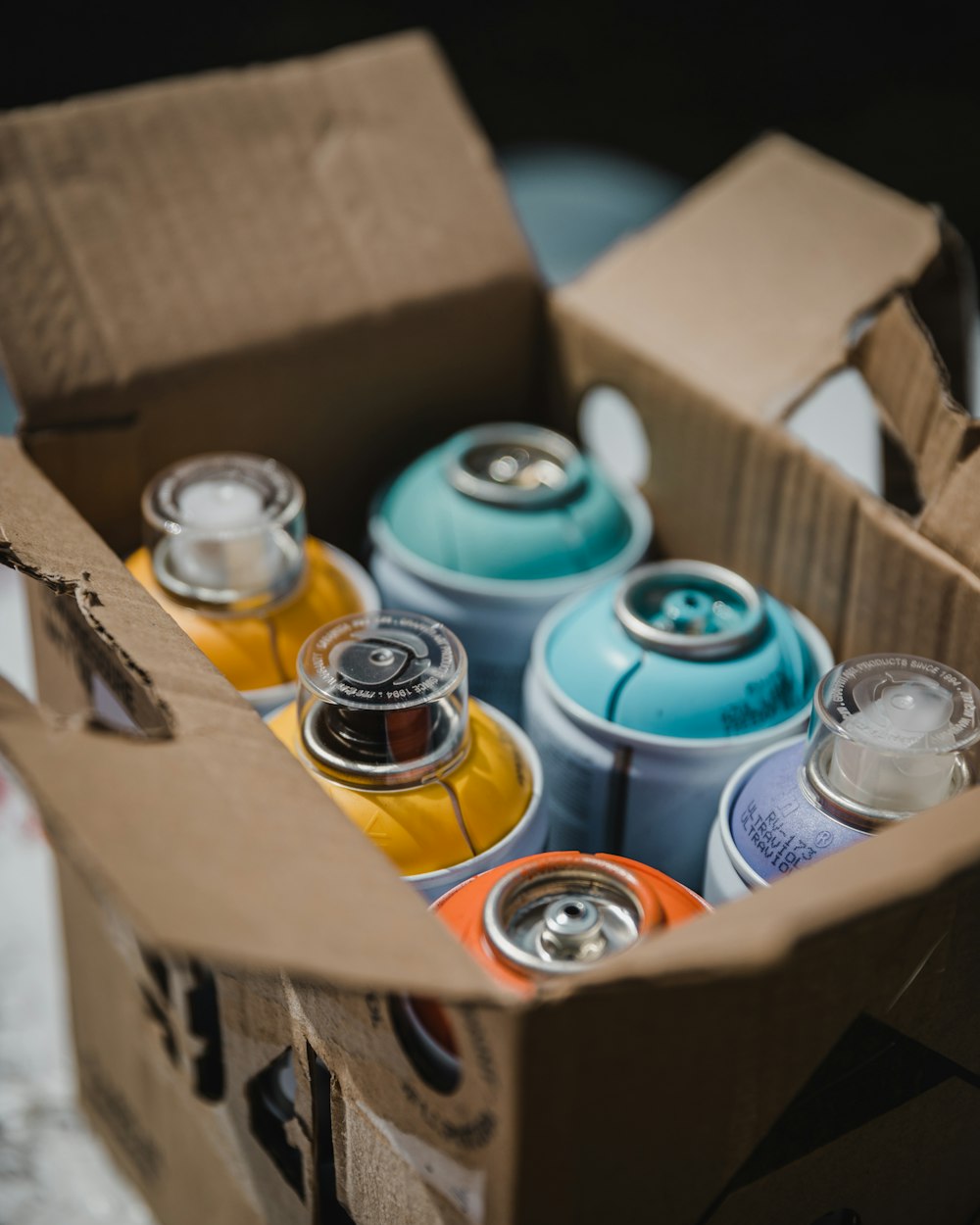 blue and orange cans on brown cardboard box
