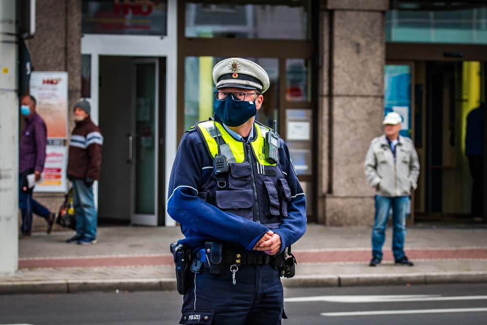 노란 헬멧과 노란 헬멧을 쓴 파란 재킷을 입은 남자가 낮에 보도에 서 있다