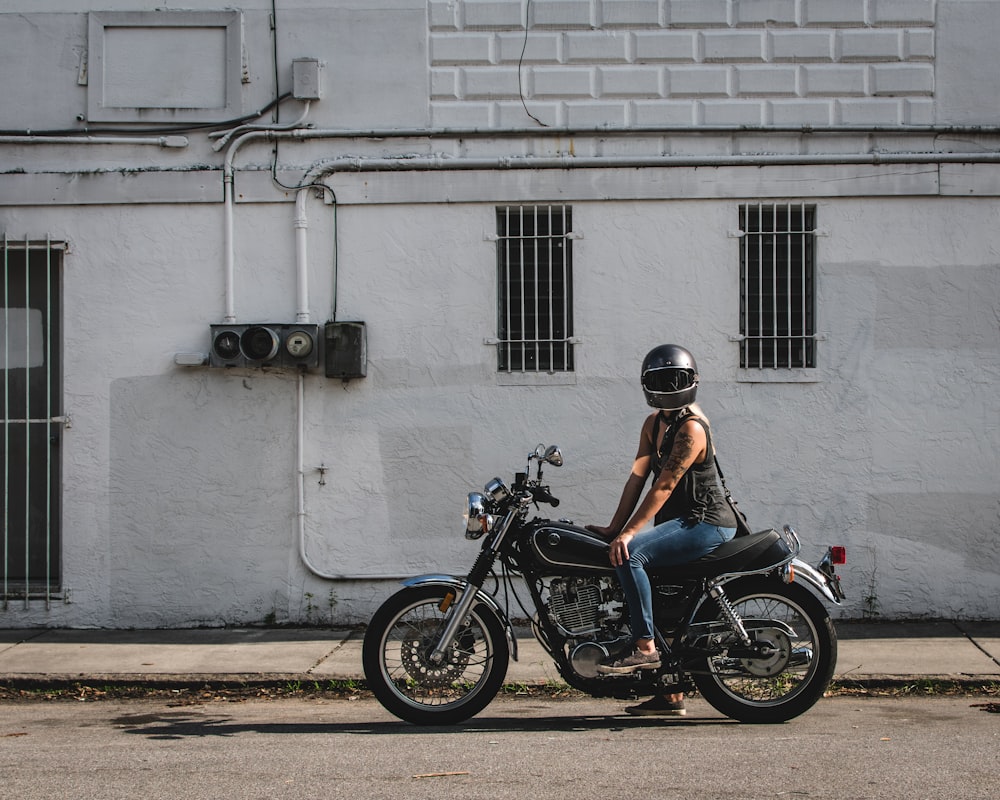 man in blue shirt riding black motorcycle