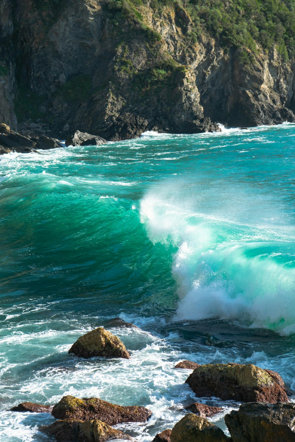 ocean waves hitting rocky shore during daytime