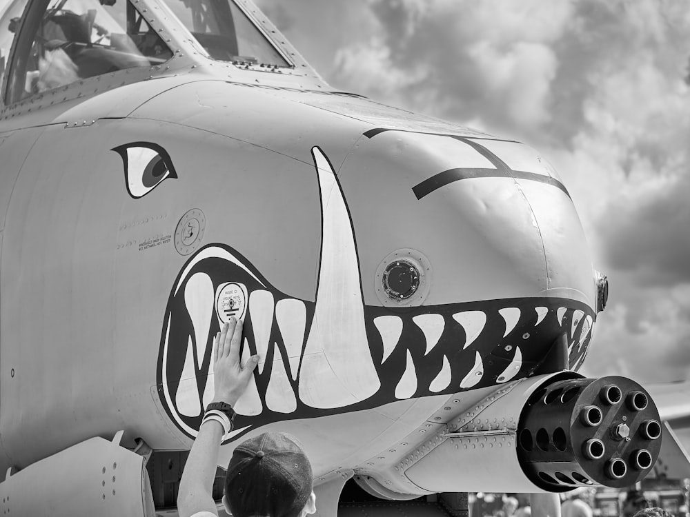 grayscale photo of airplane under cloudy sky