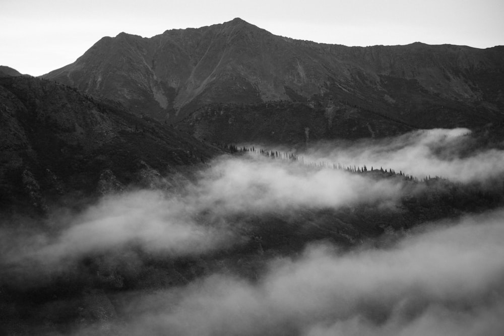 grayscale photo of mountains with fog