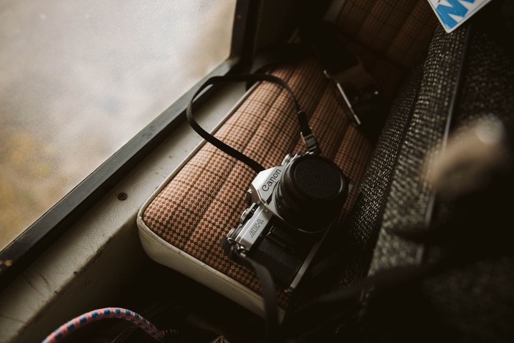 schwarz-silberne DSLR-Kamera auf braunem Holztisch