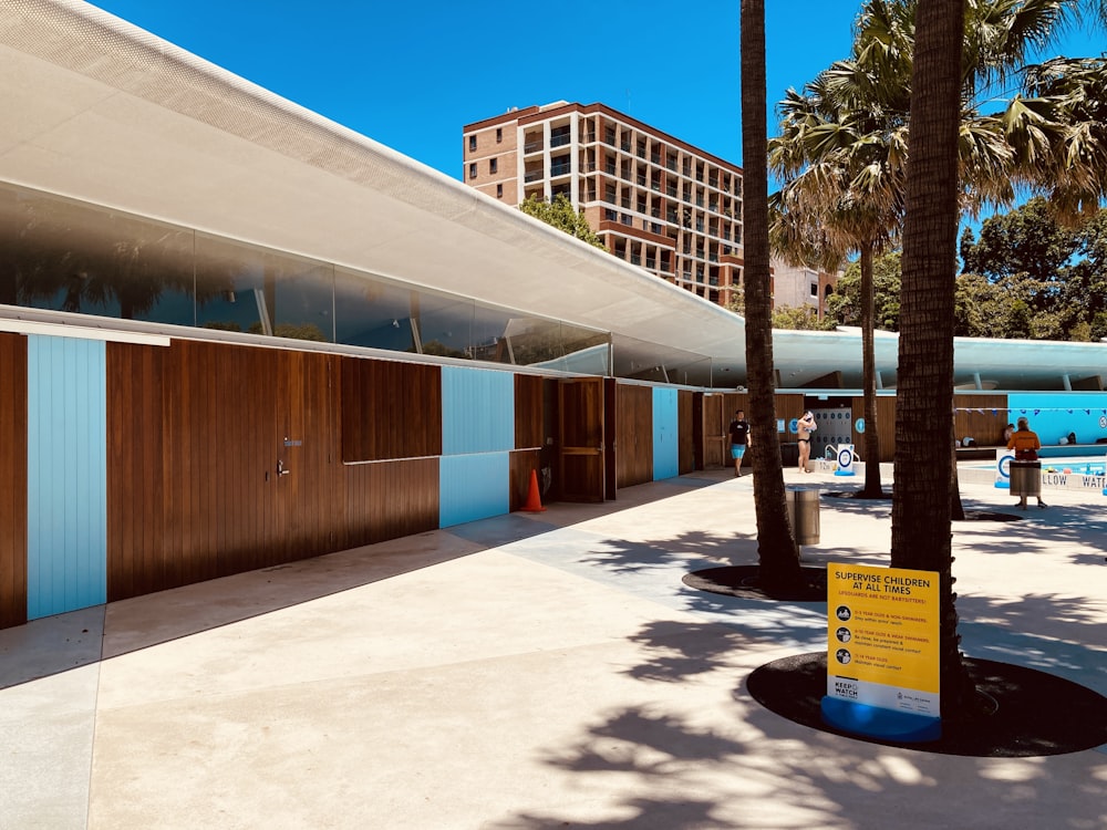 brown and white wooden building near green tree under blue sky during daytime