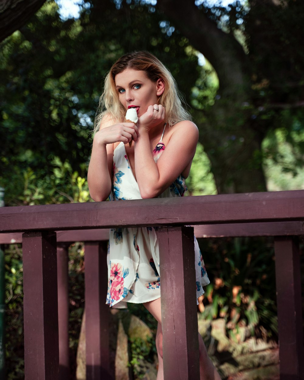 girl in white tank top sitting on brown wooden bench during daytime