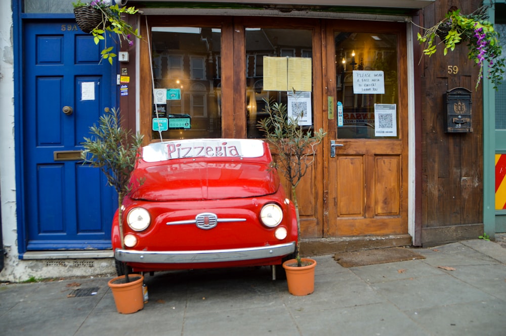red volkswagen t-2 van parked beside brown wooden building during daytime
