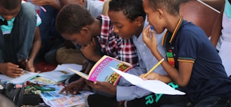 boy in blue and white plaid shirt reading book