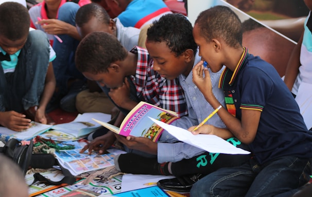 boy in blue and white plaid shirt reading book