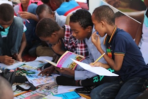 boy in blue and white plaid shirt reading book