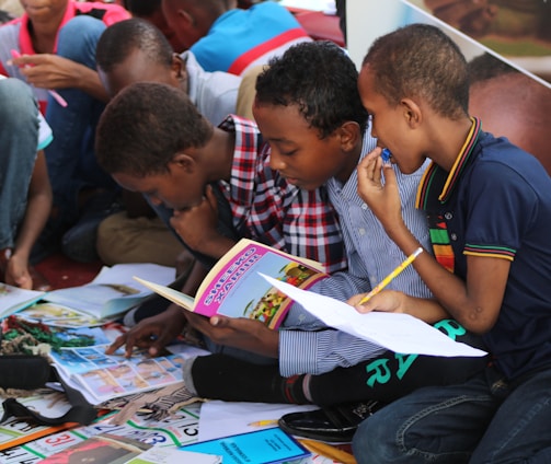 boy in blue and white plaid shirt reading book