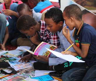 boy in blue and white plaid shirt reading book