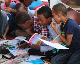 boy in blue and white plaid shirt reading book