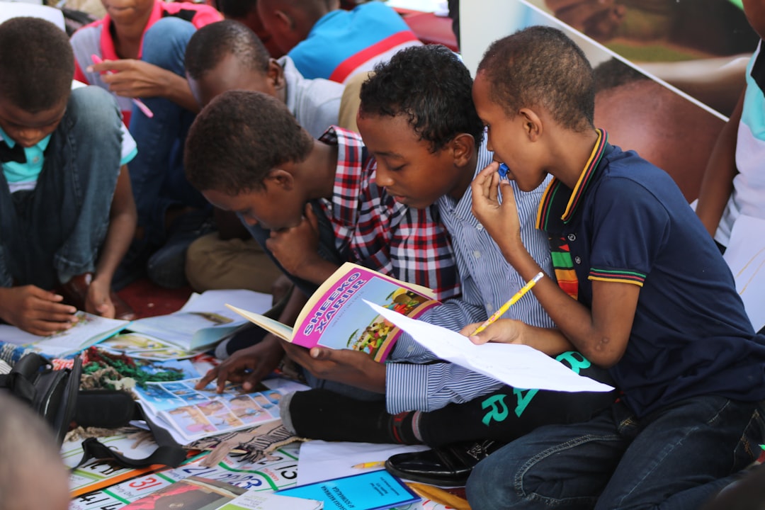 boy in blue and white plaid shirt reading book,