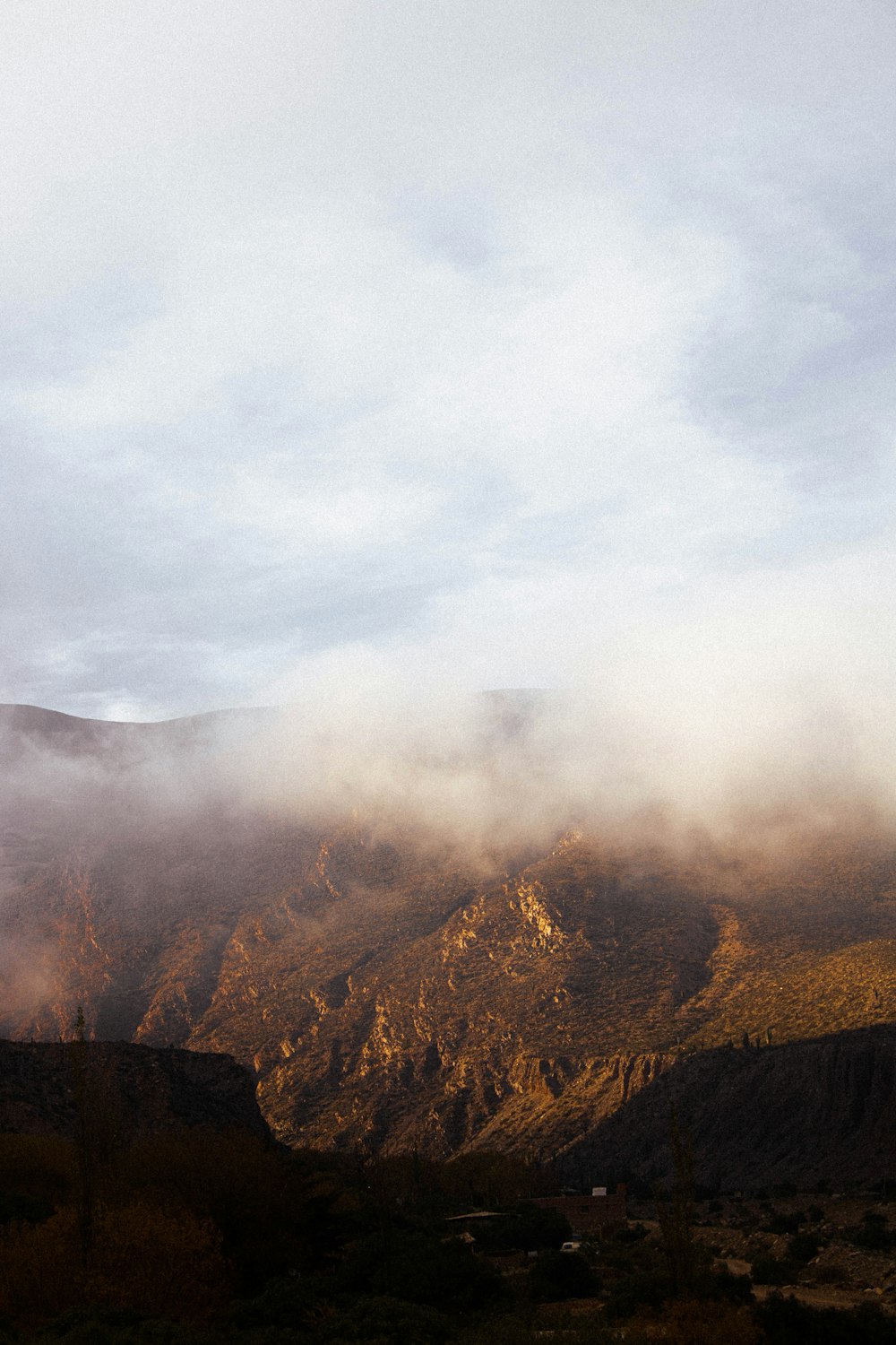 montagne brune sous des nuages blancs