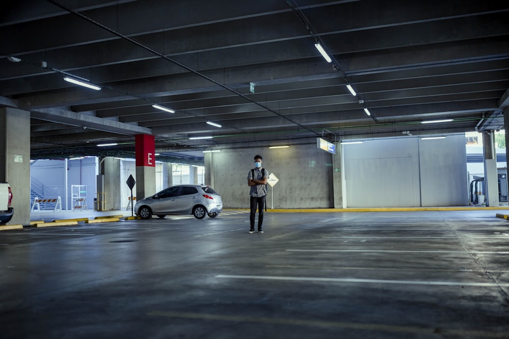 man in black jacket and black pants standing on gray concrete floor