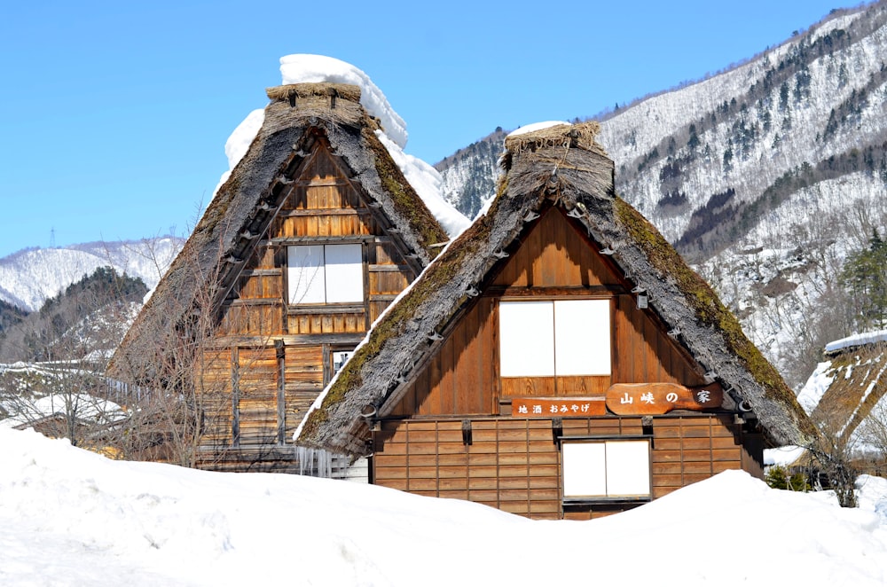 Braunes Holzhaus tagsüber auf schneebedecktem Boden