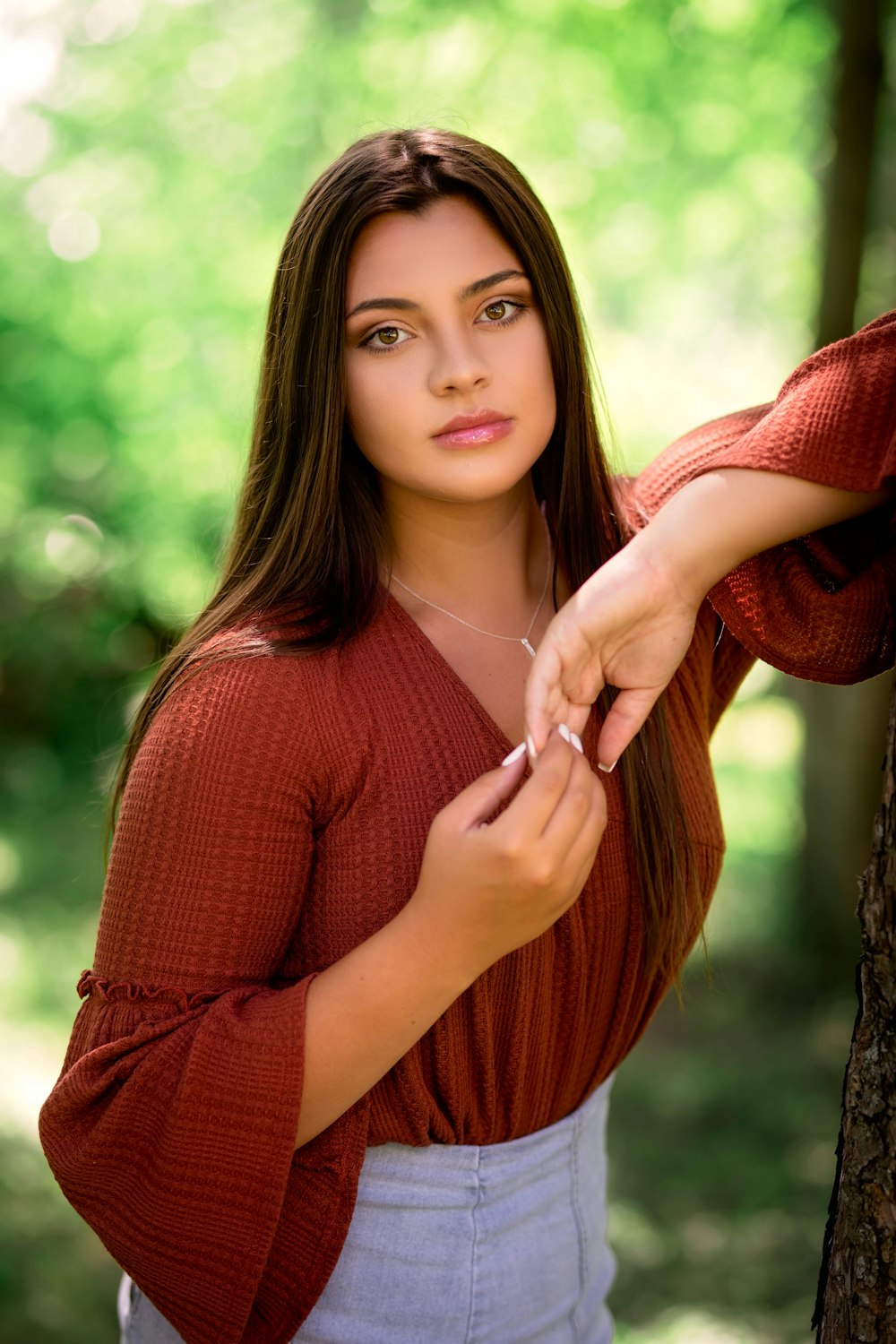 woman in red knit sweater holding her hair