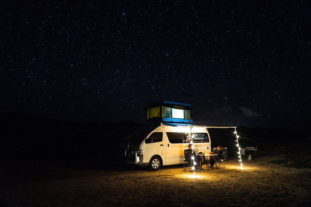 white van on brown sand during night time