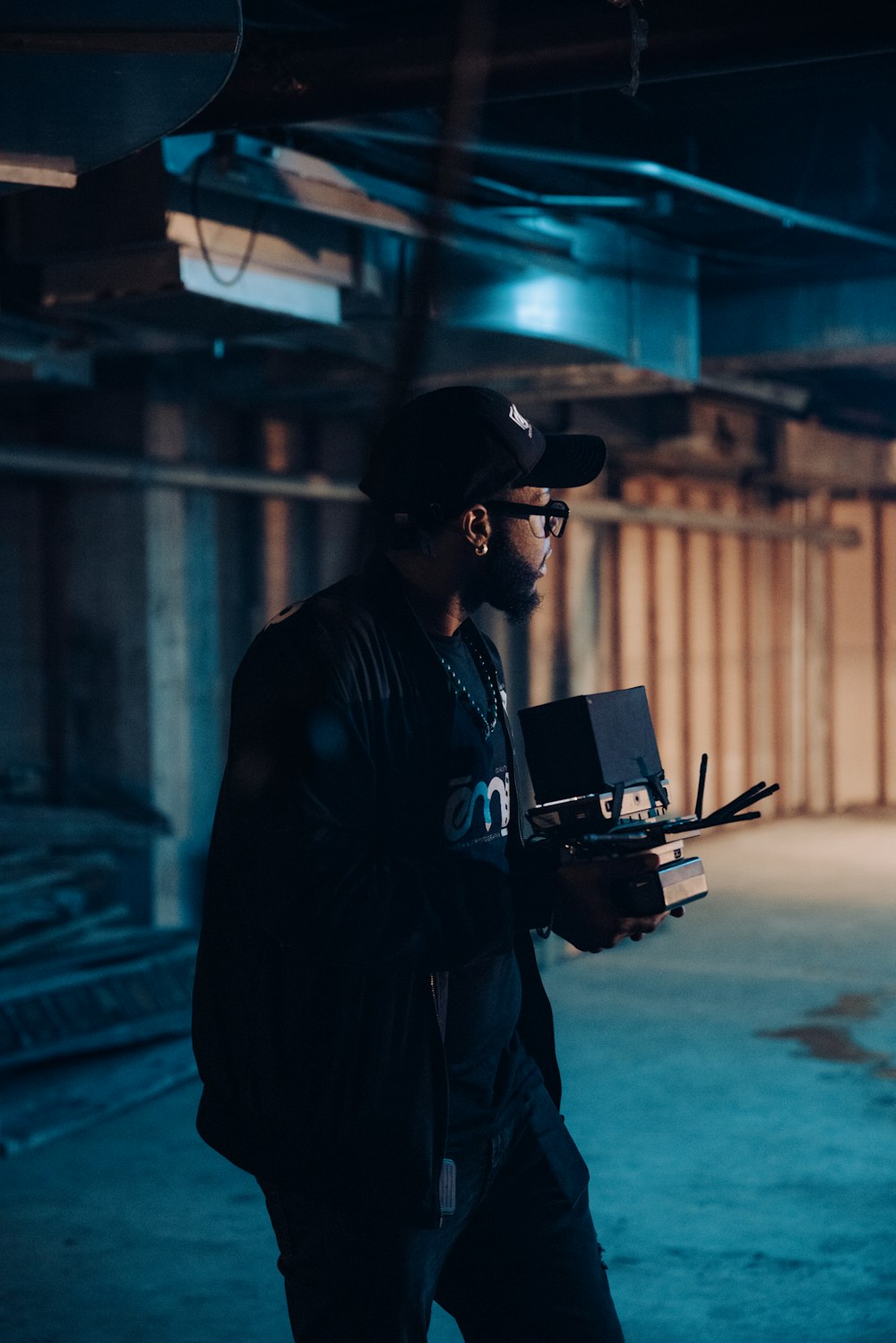 man in black jacket holding black laptop computer