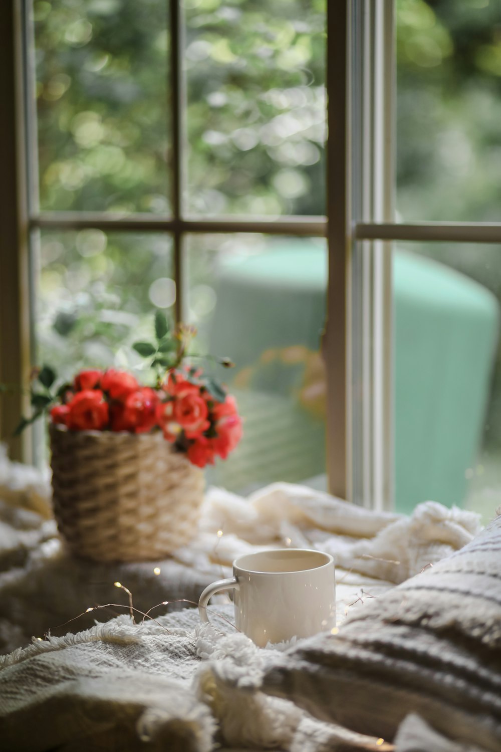 red and white flowers in brown wicker basket on table