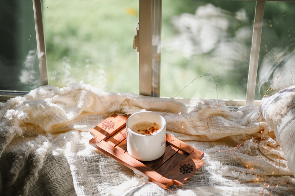 Tasse en céramique blanche sur plateau en bois brun