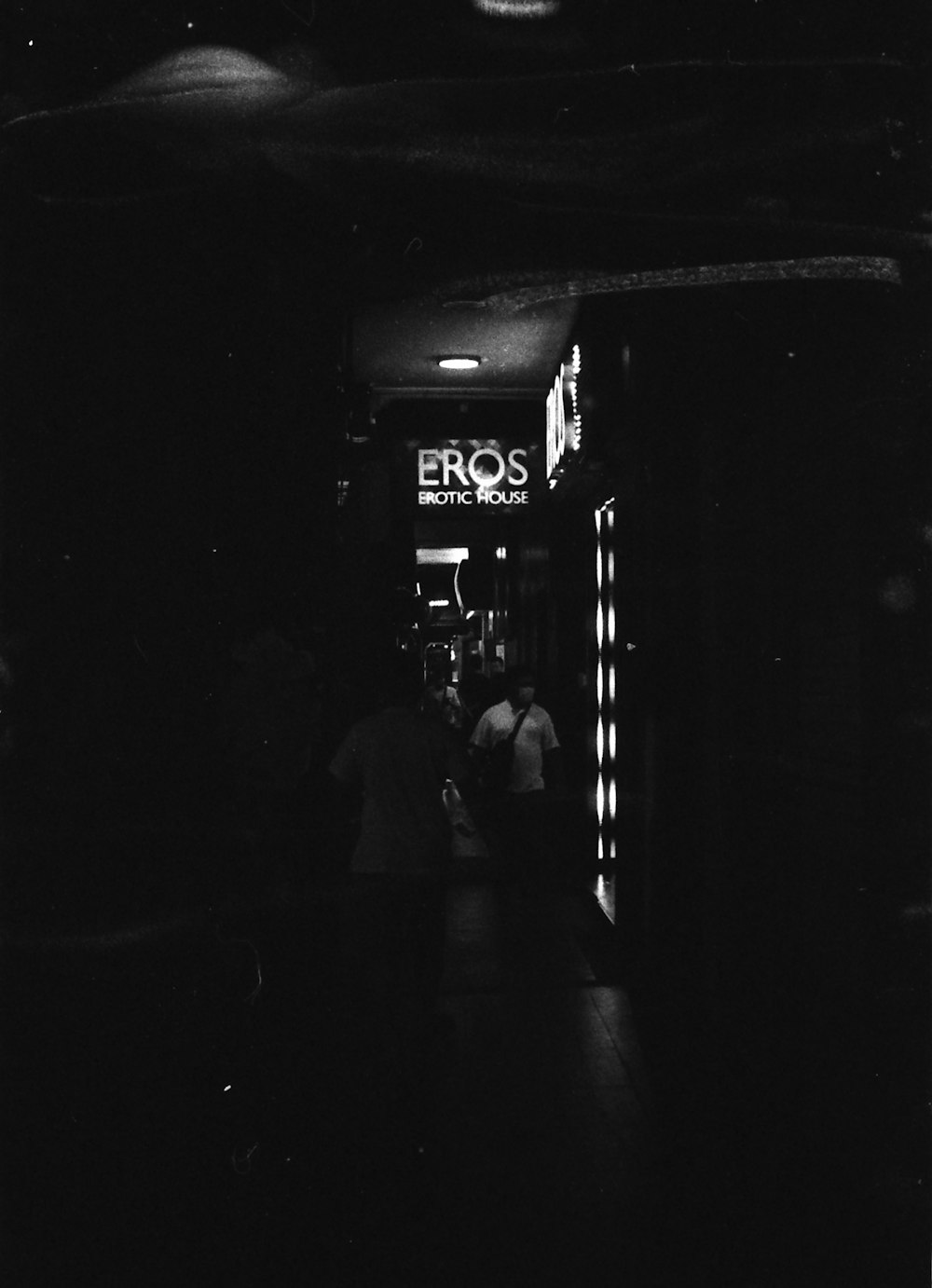 grayscale photo of people walking on sidewalk