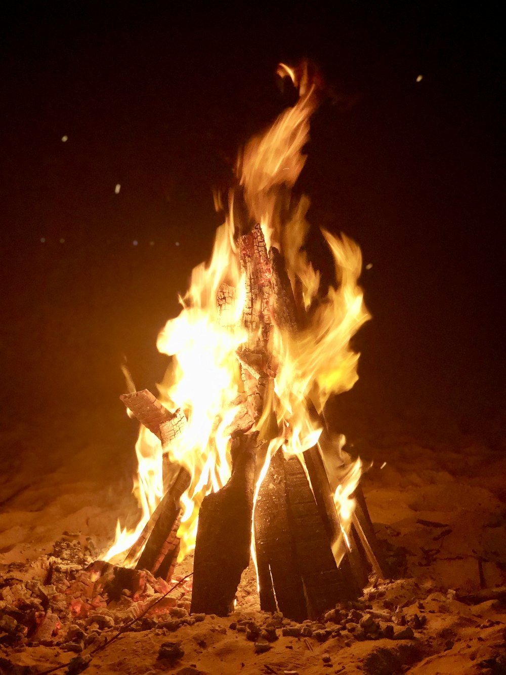 fire in the middle of the field during night time