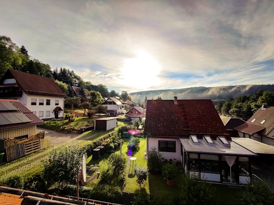 A cozy, modern residential neighborhood at sunset showing inviting homes with well-kept gardens.