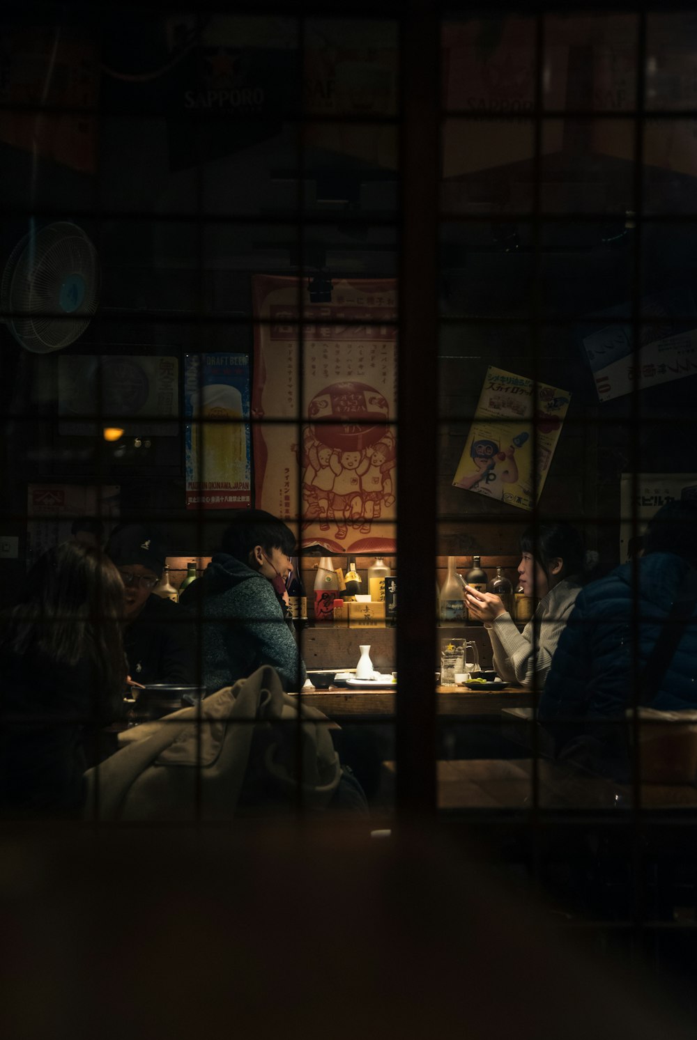 personas sentadas en una silla cerca de una ventana de vidrio