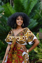 woman in brown and white floral dress standing near green plant during daytime