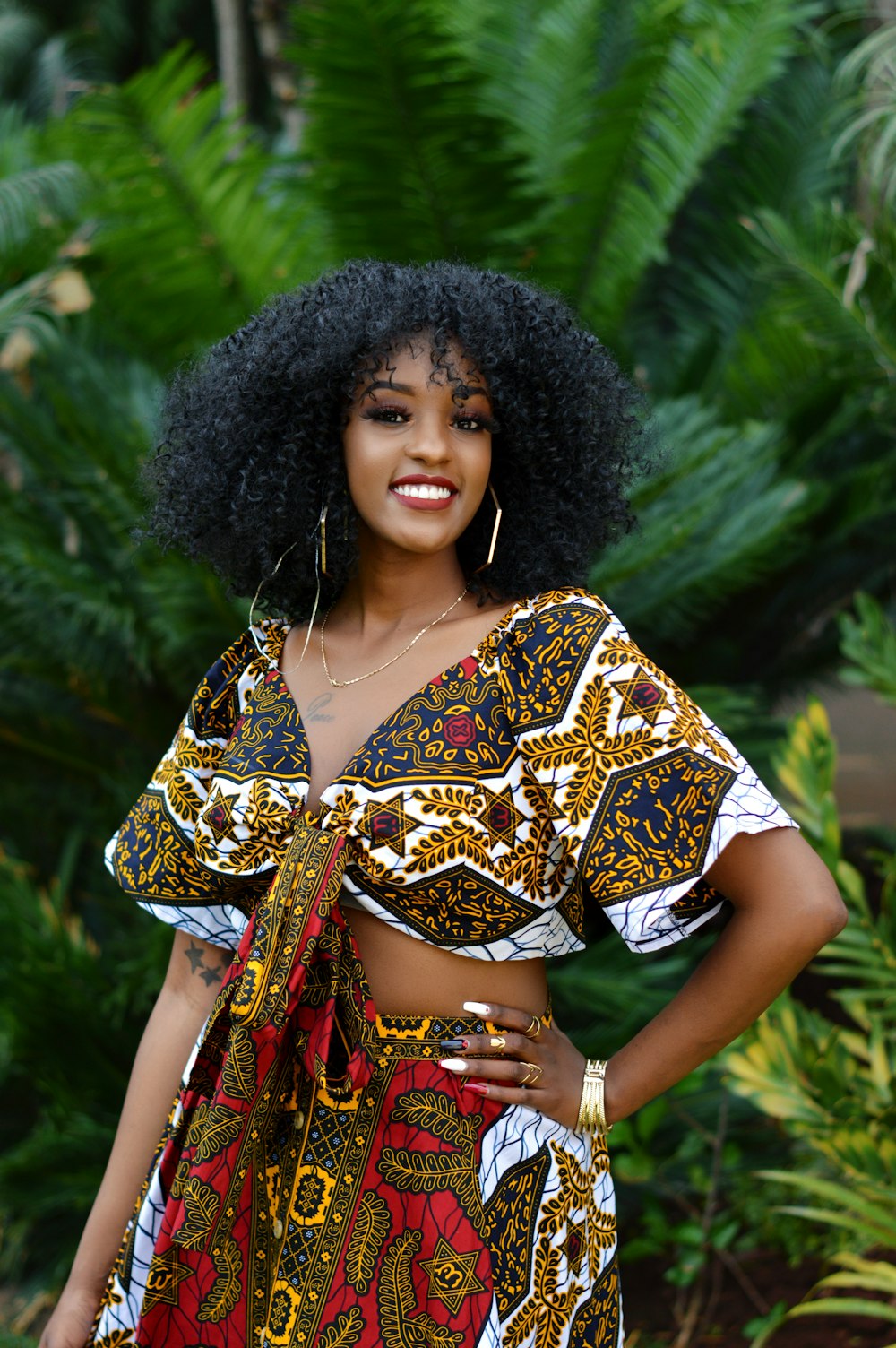 woman in brown and white floral dress standing near green plant during daytime