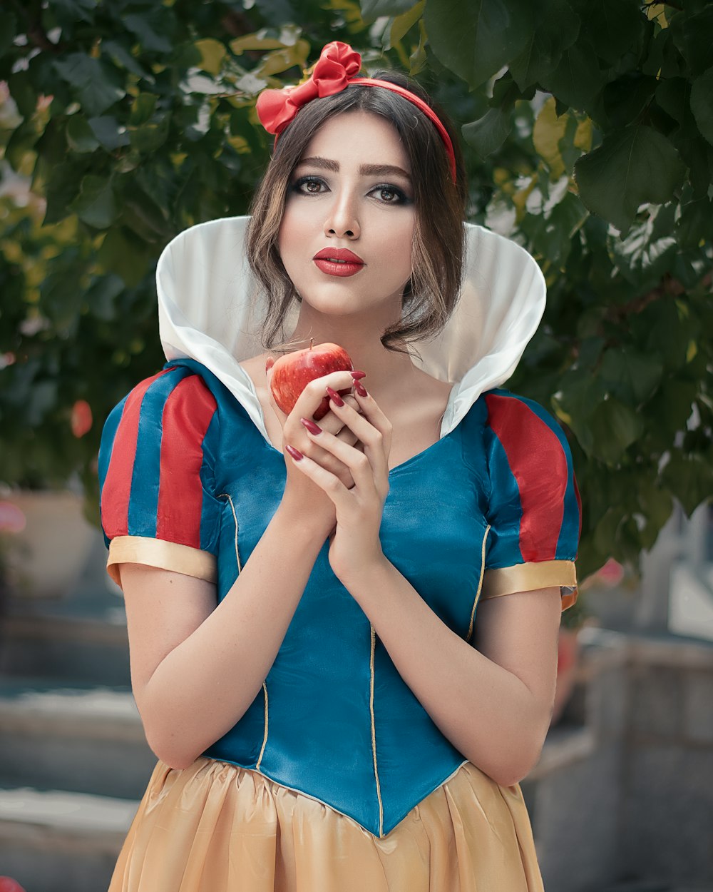 woman in red and white crew neck t-shirt holding red apple fruit