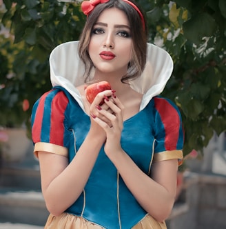 woman in red and white crew neck t-shirt holding red apple fruit