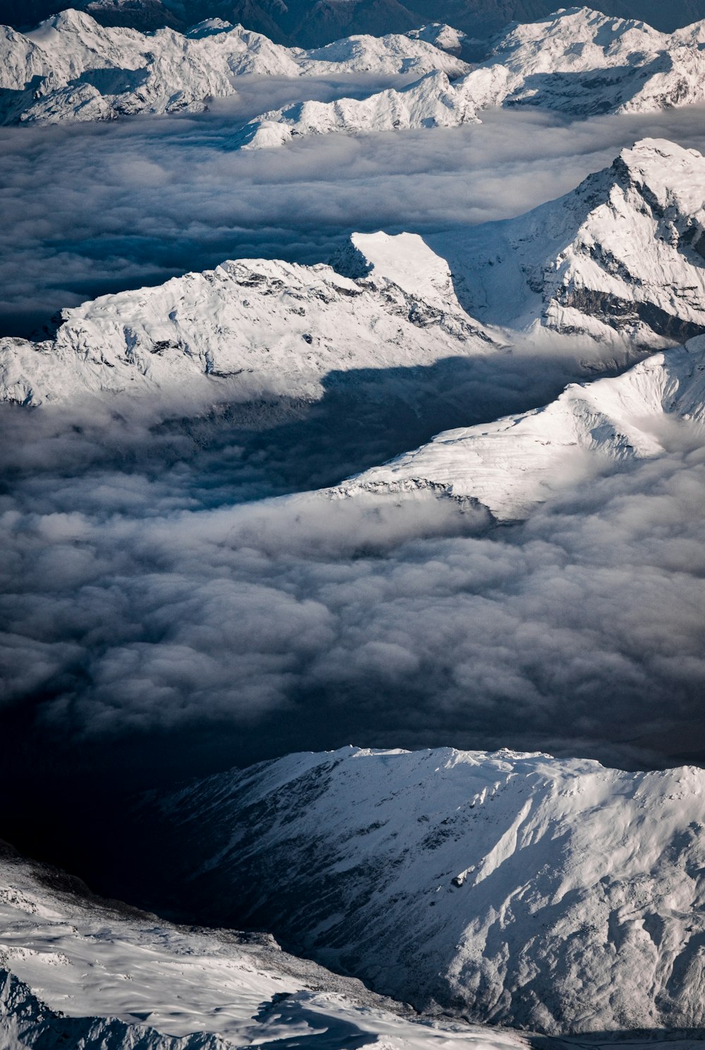montagna coperta di neve sotto nuvole bianche durante il giorno