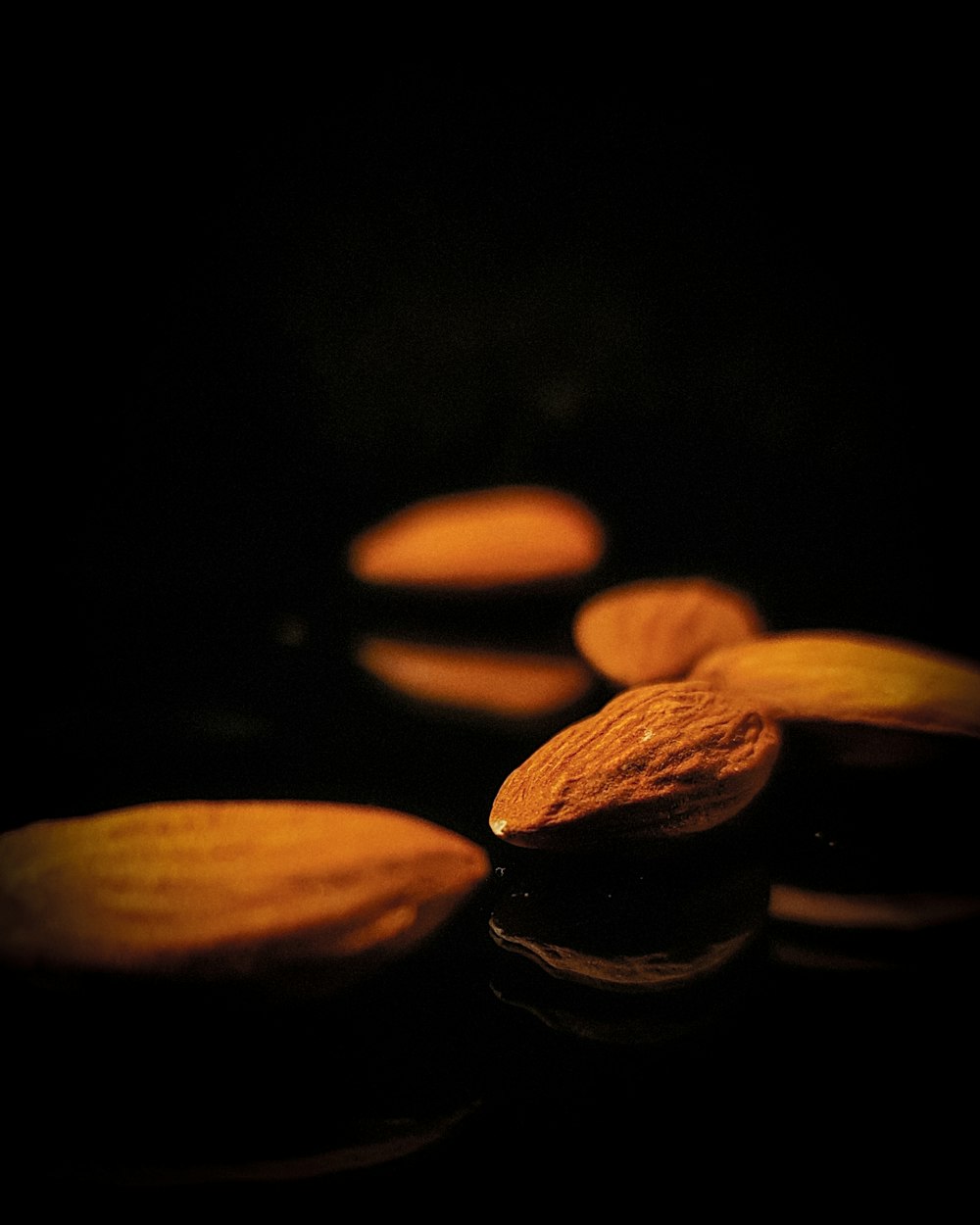 brown almond nuts on black surface