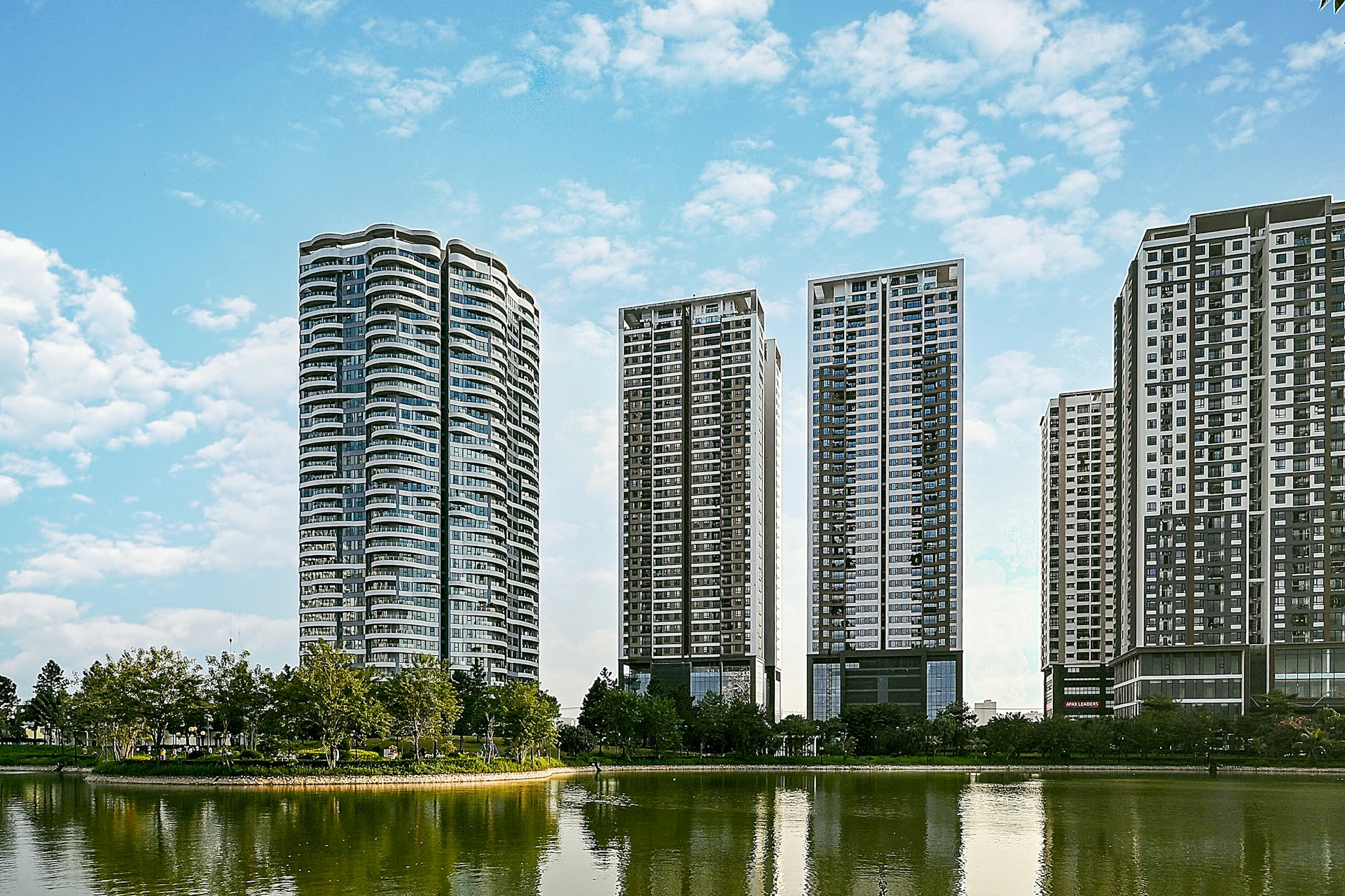 body of water near trees and high rise buildings during daytime
