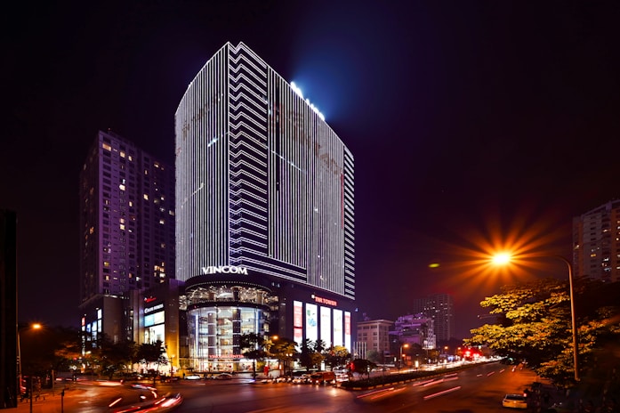 A sleek high-rise tower in Ho Chi Minh City, glowing with evening lights.