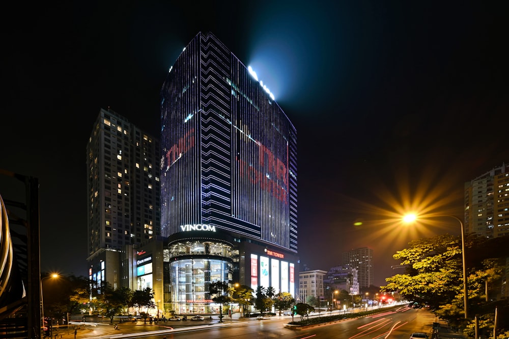 cars on road near high rise building during night time