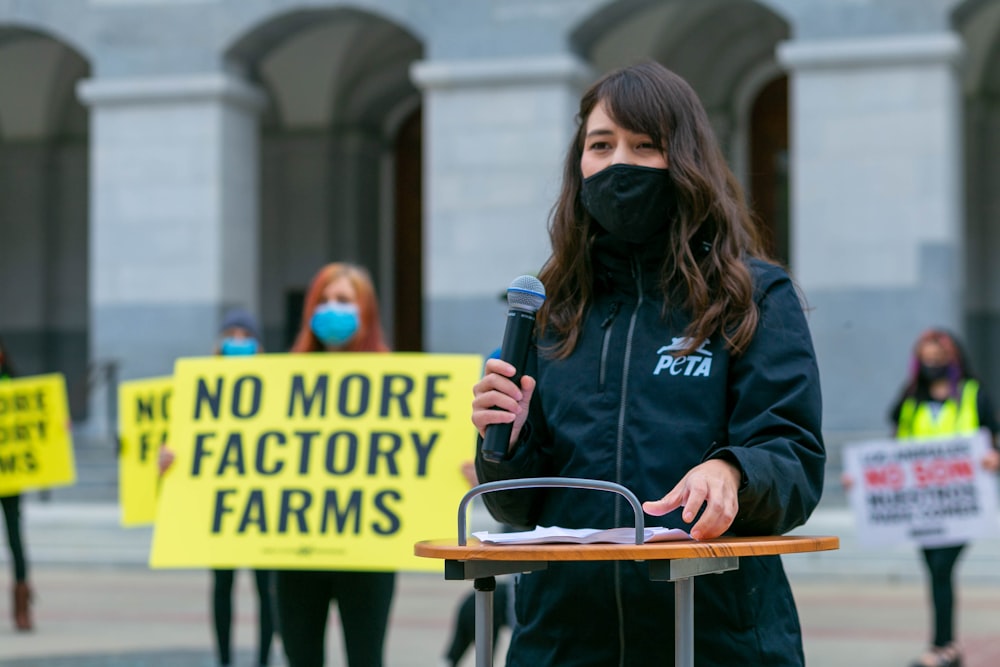 woman in blue jacket holding black microphone