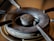 A close-up view of a gas stove burner with visible wear and tear, displaying rust and grime accumulated over time. The metal surface shows discoloration, and the central gas outlet is prominent.
