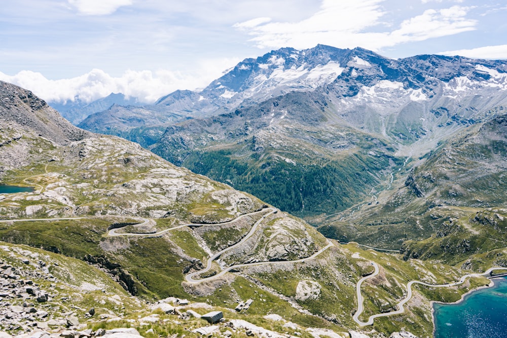 montagnes vertes et grises sous un ciel blanc pendant la journée