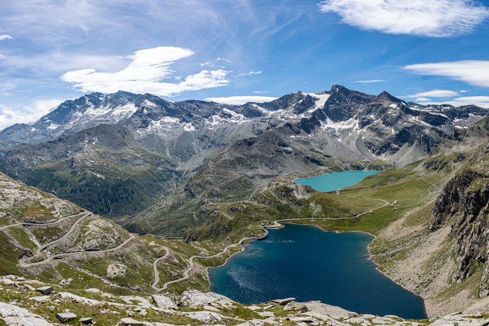 lake in the middle of mountains under blue sky