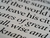 Close-up of delicate serif typography on an off-white page with soft shadows.