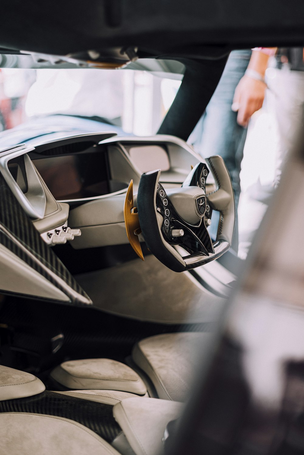 person in white long sleeve shirt standing beside black and silver car