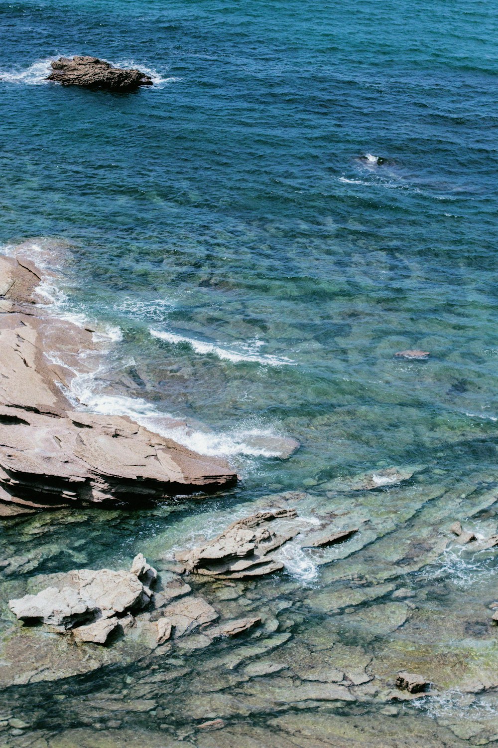 brown rock formation beside body of water during daytime