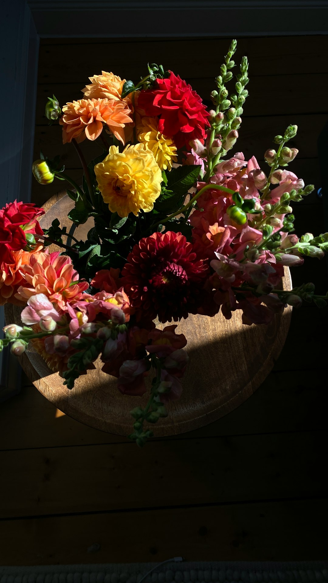 yellow pink and purple flowers on brown wooden table