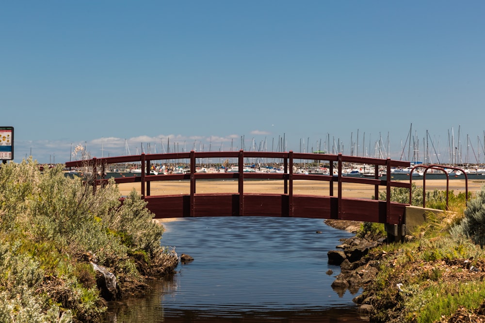 brown wooden bridge over river under blue sky during daytime