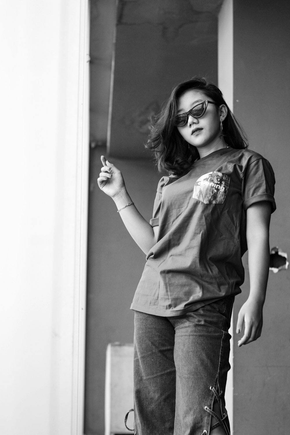 grayscale photo of woman in t-shirt and denim jeans